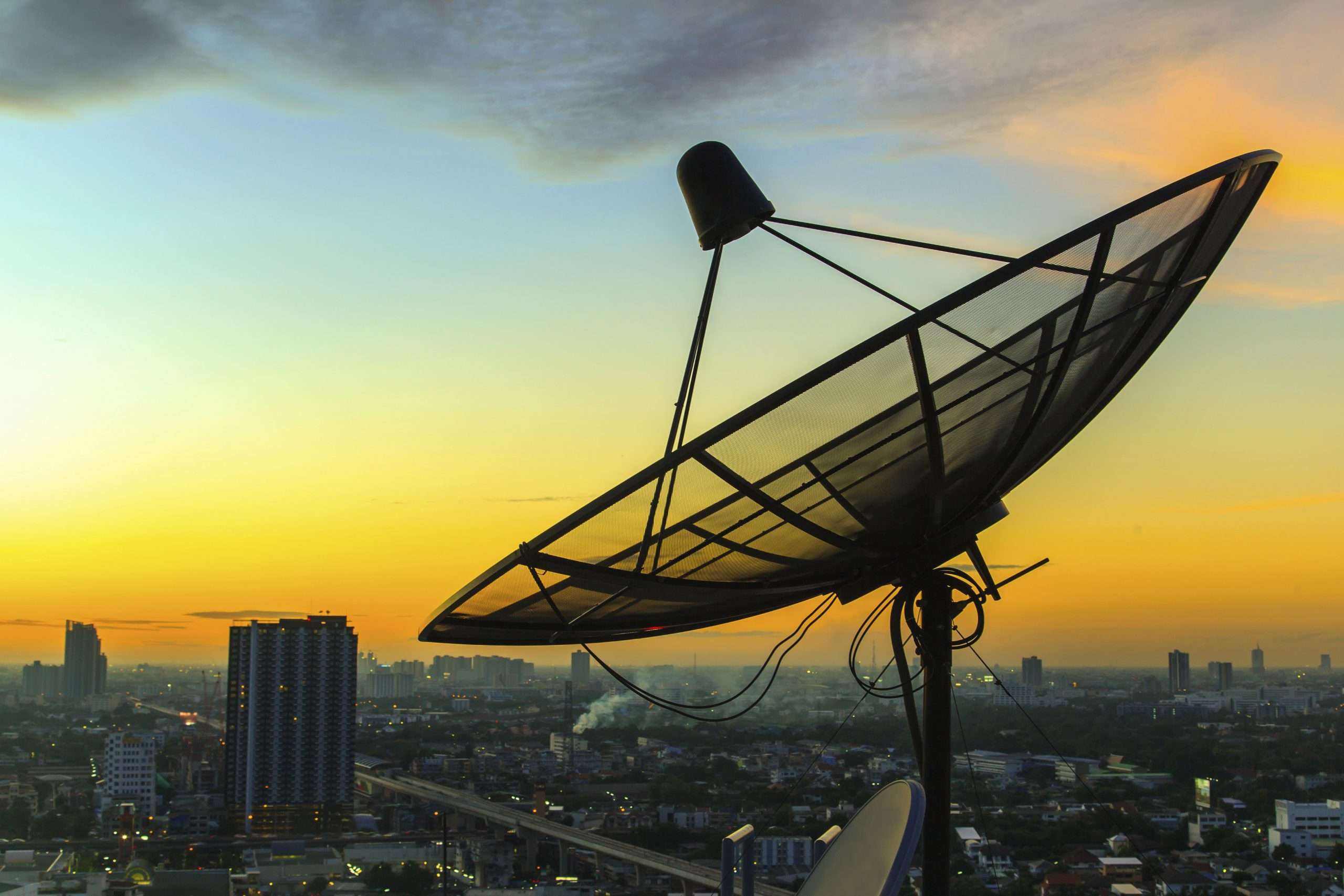 I satellite dish pointing to the sky at sundown or sunset.